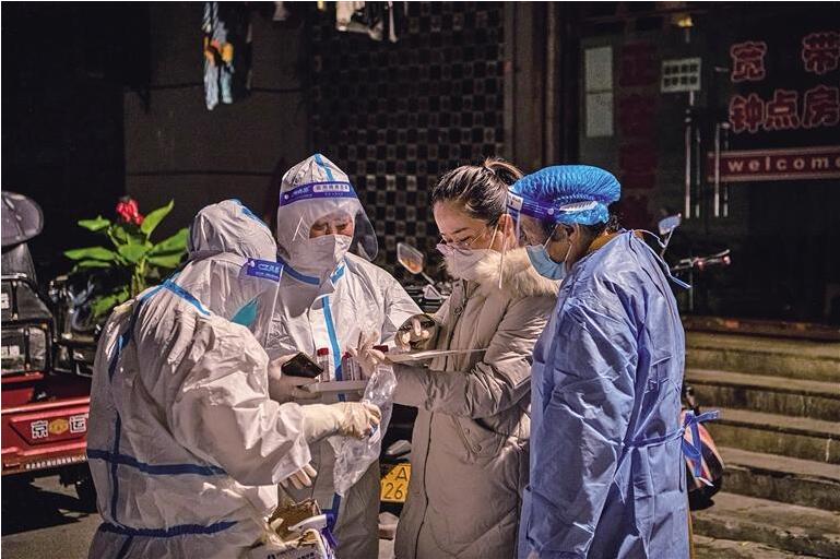 西安市新城区东大院社区工作人员与医护人员、志愿者核对上门核酸名单。.jpg